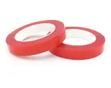 Zwei Rollen rotes Schaumklebeband liegen nebeneinander auf weißem Hintergrund.