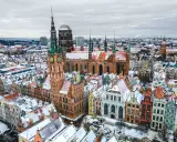 Zimowy widok na Gdańsk. Ratusz Głównego Miasta i Bazylika Mariacka w śniegu. Wspaniałe gdańskie atrakcje turystyczne.