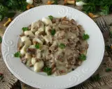 Polędwiczki w sosie kurkowym z kluskami, udekorowane natką pietruszki. Pyszne danie na jesienny obiad.