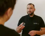 Terapeuta pokazuje bańkę, wyjaśniając, gdzie stawiać bańki na kaszel.