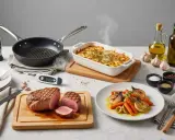 Filet de porc rôti, gratin fumant, légumes rôtis et thermomètres de cuisson. Idéal pour le temps de cuisson parfait d'un filet de porc au four.