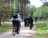 Grupa rowerzystów przemierza leśną ścieżkę, spalając kalorie podczas aktywnej jazdy na rowerze.