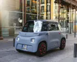 Citroën Ami gris en movimiento por la ciudad. Descubre el carnet AM precio y disfruta de la movilidad urbana.
