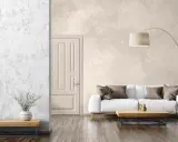 Un salon moderne avec un mur texturé en enduit décoratif, un canapé blanc, une table basse en bois et une plante verte.