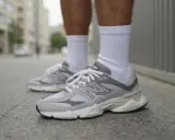 Szare buty New Balance na miejskim chodniku. Stylowy poradnik, jak nosić klasykę.