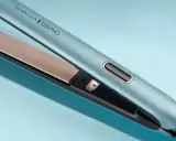 Niebieska prostownica Remington Shine Therapy PRO z złotymi płytkami na jasnoniebieskim tle.