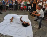 Danza contemporanea durante la festa patronale Galatina. Un performer si muove su un telo bianco, ripreso da un operatore.