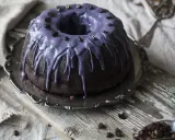 Mörk chokladkaka med lila glasyr och kaffebönor, perfekt för ett chokladkaka recept.