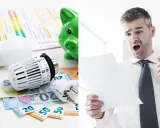 Chockad man ser en elräkning. Glödlampa, element och sedlar antyder höga kostnader, kanske relaterade till kw vs kwh.