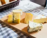 Deska z różnymi rodzajami serów, w tym ser włoski z niebieską pleśnią, idealny na degustację.