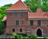 Zamek w Łęczycy, jedna z głównych atrakcji regionu, otoczony zielenią.