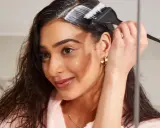 Mujer aplica producto para aclarar pelo castaño oscuro sin decolorar.