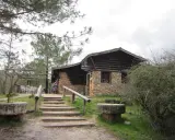 Mesones Riopar: acogedor bar-restaurante de piedra y madera en un entorno natural. Escaleras de acceso y mesas exteriores invitan a disfrutar.