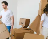 Un couple déménage, entouré de cartons. Le bail est au nom d'un seul, mais ils vivent ensemble.