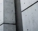 Superficie de hormigón con fibra de polipropileno, mostrando texturas y juntas oscuras entre bloques.