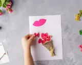 Manos creando flores manualidades con pasta de moño rosa, un ramo y labios de papel.