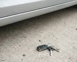 Zgubione kluczyki od samochodu leżą na betonie. Brak zapasowych, co oznacza kłopoty.