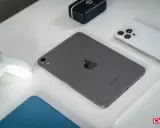Szary iPad mini, biały kontroler do gier, biały iPhone i rysik na białym tle.
