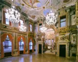 Intérieur somptueux d'un palais labia, avec lustres en cristal, fresques au plafond et tentures de velours rouge.