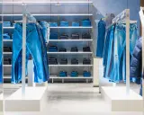 Sklep z jeansami G-Star RAW. Wieszaki uginają się pod ciężarem niebieskich spodni, na półkach poukładane są kolejne pary.