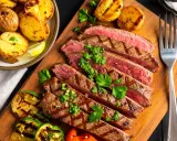 Saftig flankstek, perfekt grillad och skivad, serveras med klyftpotatis och grillade grönsaker. Ett fantastiskt flankstek recept för en härlig middag.