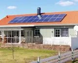 Hus med solpaneler på taket. Undrar du över batteri till solceller pris?