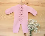 Precioso pelele punto bebé rosa con botones de madera y delicado encaje. Perfecto para un recién nacido.