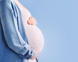 Pancia di donna incinta, con mani che la accarezzano. Si percepiscono le contrazioni di Braxton Hicks, un dolce preludio.