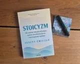 Zeszyt ćwiczeń "Stoicyzm. Jak zyskać zdrowy dystans, wpływ na własne życie i wewnętrzny spokój" obok zielonego pióra. Sztuka życia według stoików.