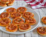 Deliciosas galletas de hojaldre con salsa de tomate y queso, perfectas para un aperitivo.