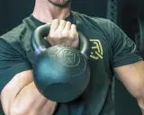 Mann hält Kettlebell, bereit für einen Kettlebell Workout Plan.