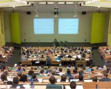 Wykład na uczelni w Szczecinie. Studenci słuchają wykładowcy na tle tablic z równaniami matematycznymi.