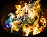 Fiamme danzanti in un braciere, con sfumature blu e verdi che si mescolano all'oro. Un'arte nel fotografare il fuoco.