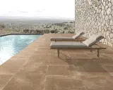Elegante suelo para piscinas de tonos tierra, con tumbonas y vistas a un paisaje natural.