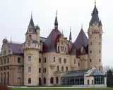 Imponujące pałace w Polsce, jak ten z kamienia i czerwonym dachem, zachwycają wieżami i detalami architektonicznymi.