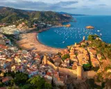 Widok na średniowieczne miasteczko z zamkiem i zatokę pełną łodzi. To idealne miejsce na odkrywanie atrakcji Costa Brava.