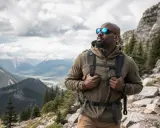 Uomo con zaino e occhiali da sole fa escursioni in montagna, godendosi il panorama mozzafiato.