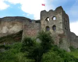 Ruiny zamku w Czorsztynie, z polską flagą na wieży. Warto kupić zamek w Czorsztynie bilety i zwiedzić to miejsce.