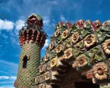 Bunte Sonnenblumen zieren die Fassade eines Turms in Comillas, Spanien.