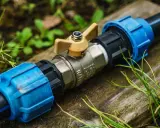 Metalowy zawór z żółtą rączką, połączony z rurami PE. Instalacja wodna w ziemi, gotowa do użytku.