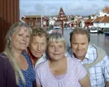 Anki Larsson och hennes vänner ler mot kameran i en charmig svensk kustby.