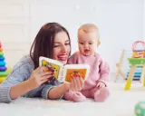Mama czyta książeczkę kolorową, a jej 2 letnie dziecko z zaciekawieniem słucha.
