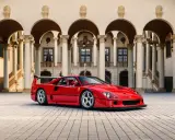 Ein roter Ferrari F40 steht vor einer prächtigen Villa mit Säulengängen.