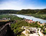 Widok na malowniczą dolinę Wachau z ruinami zamku, rzeką Dunaj i winnicami.