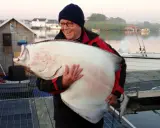 Szczęśliwy wędkarz z ogromnym halibutem. Taka zanęta halibut na jakie ryby? Na rekordowe!