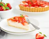 Pyszna tarta z truskawkami, z kremowym nadzieniem i chrupiącym spodem, czeka na spróbowanie.
