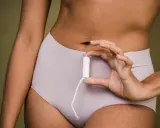 Mano sostiene un tampón. ¿Buscas cómo adelantar la regla?