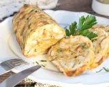 Frisch aus dem Ofen: herzhafte Brezenknödel mit Petersilie, auf einem Teller mit Messer und Gabel angerichtet.