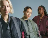 Trzy kobiety w kurtkach bomberkach Alpha Industries. To znana marka odzieży lotniczej.