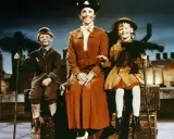 Mary Poppins z dzieciakami na dachu, z miotłami. Wszystko wygląda jak z bajki, a litery w napisach filmowych mogłyby być w stylu czcionka Poppins.